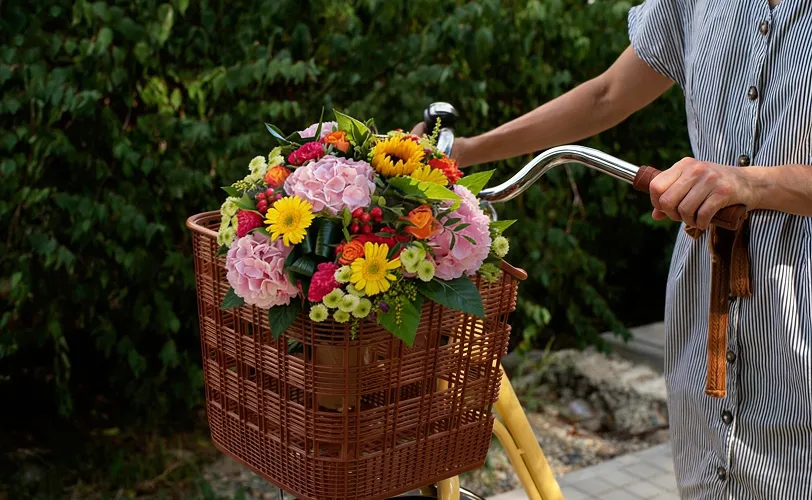 bouquet de fleurs dans le panier d'un vélo