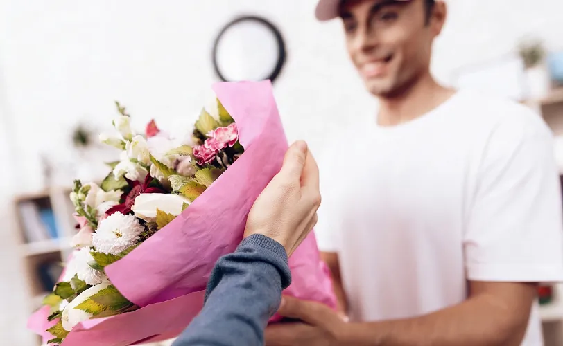 fleuriste en train de donner un bouquet de fleurs à un client